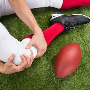 An injured football player holding their knee